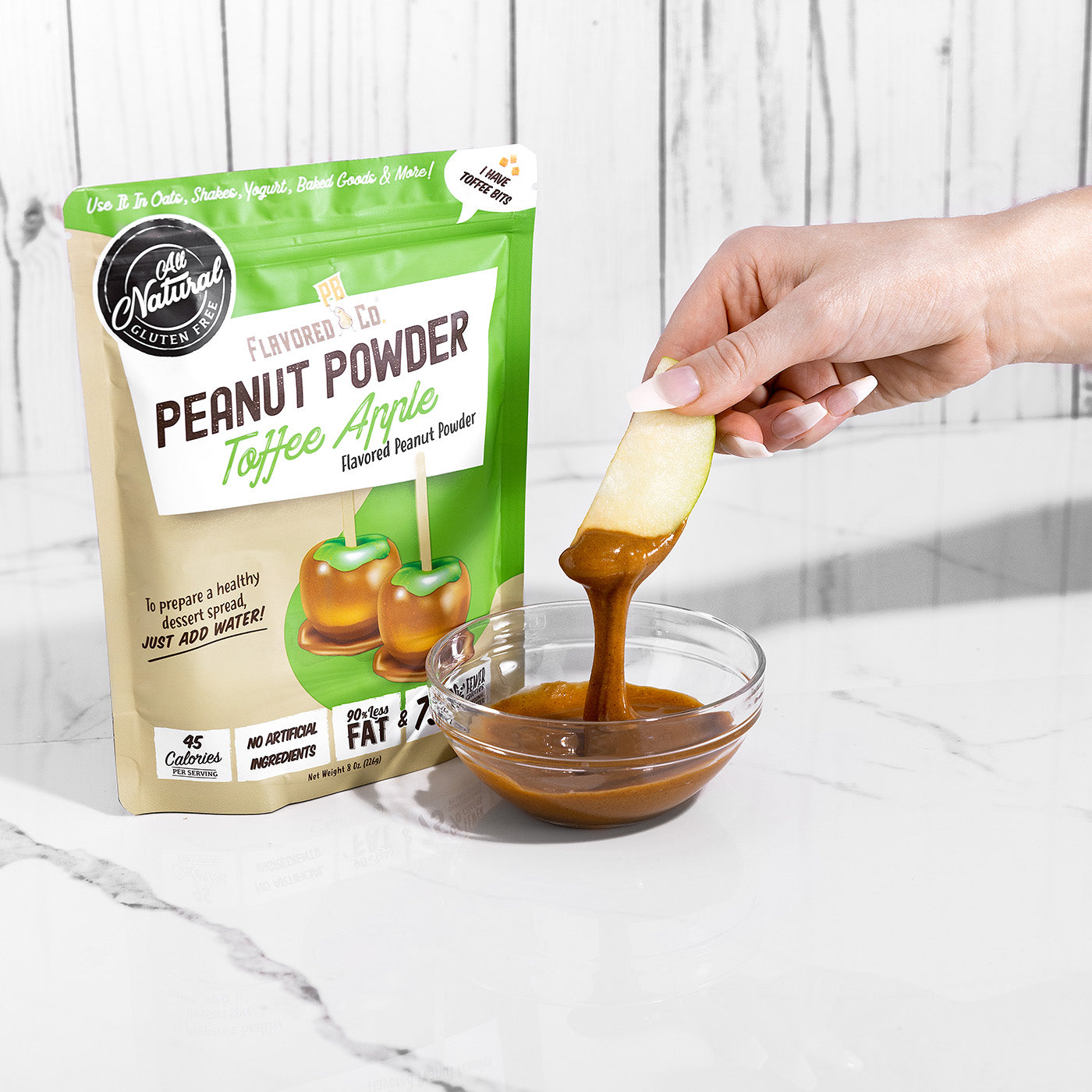 dipping apples in Flavored PBco toffee apple peanut powder